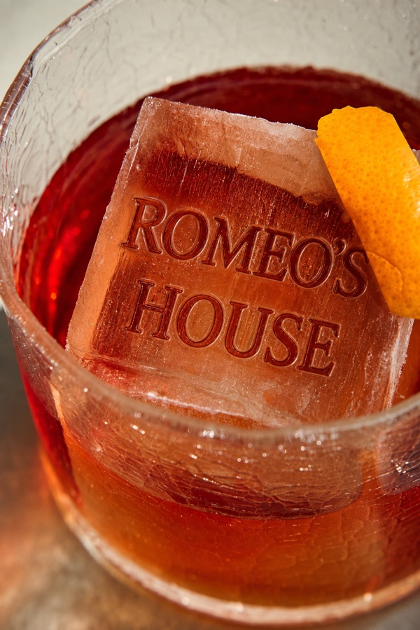 A Romeo's House branded ice block in a negroni with an orange twist
